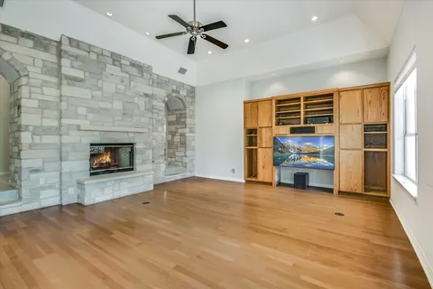 a view of empty room with wooden floor and fireplace