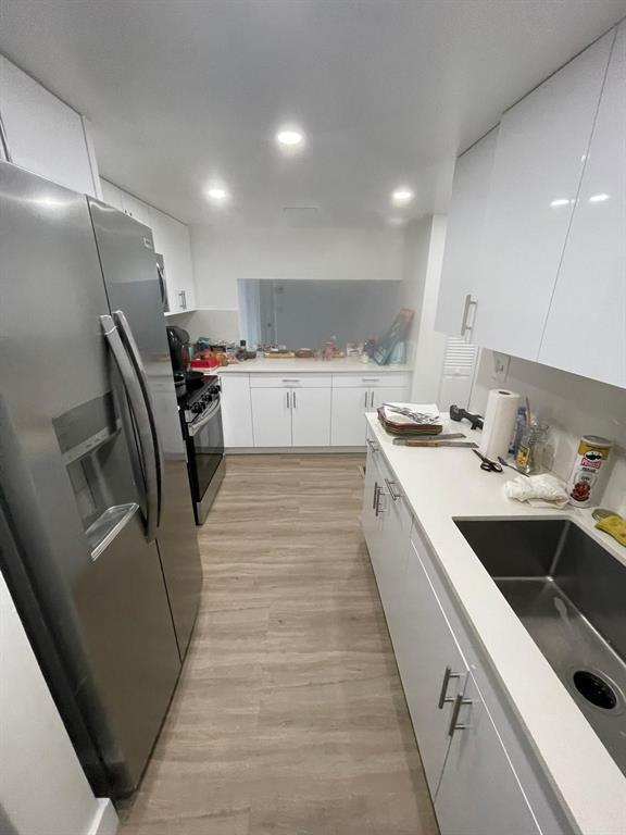 7040 Coral Way Miami, FL 33155 - Photo 2 of 10 a kitchen with a sink a refrigerator and cabinets