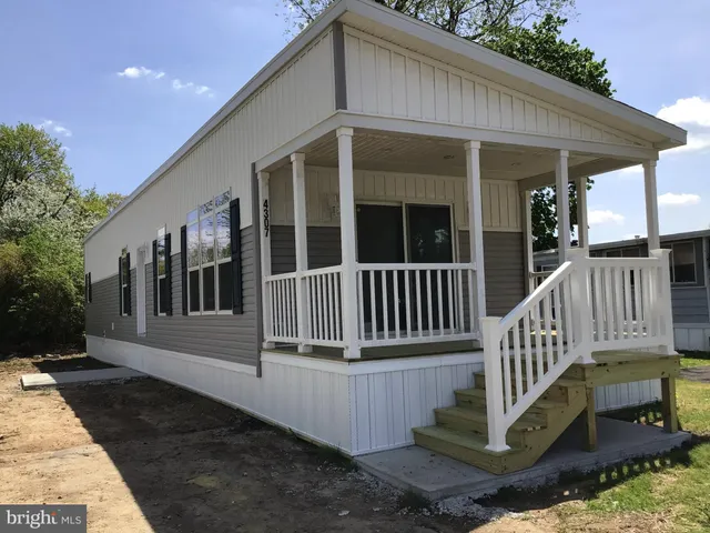 a view of a house with wooden deck and a floor to ceiling window