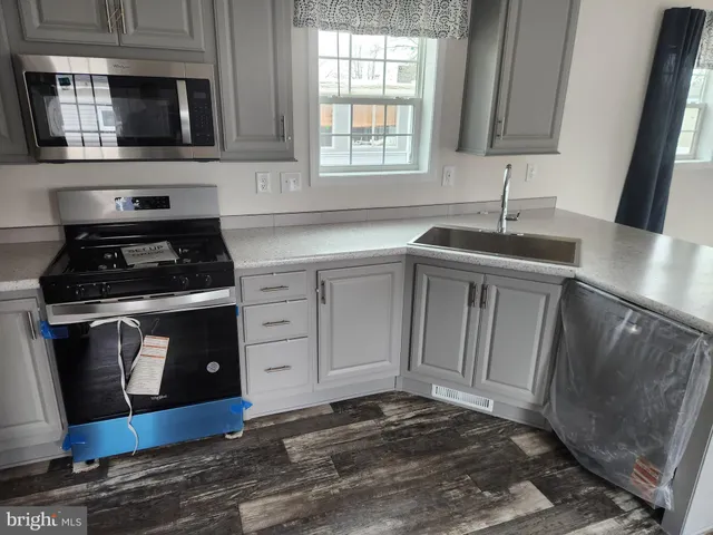 a kitchen with stainless steel appliances a stove a sink and a microwave