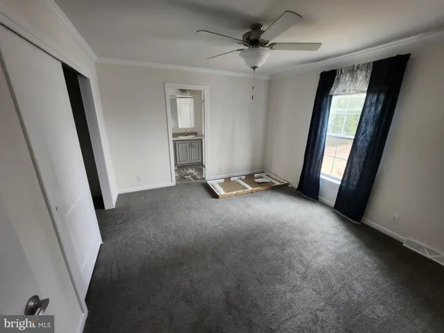 a view of a livingroom with an empty space and a ceiling fan