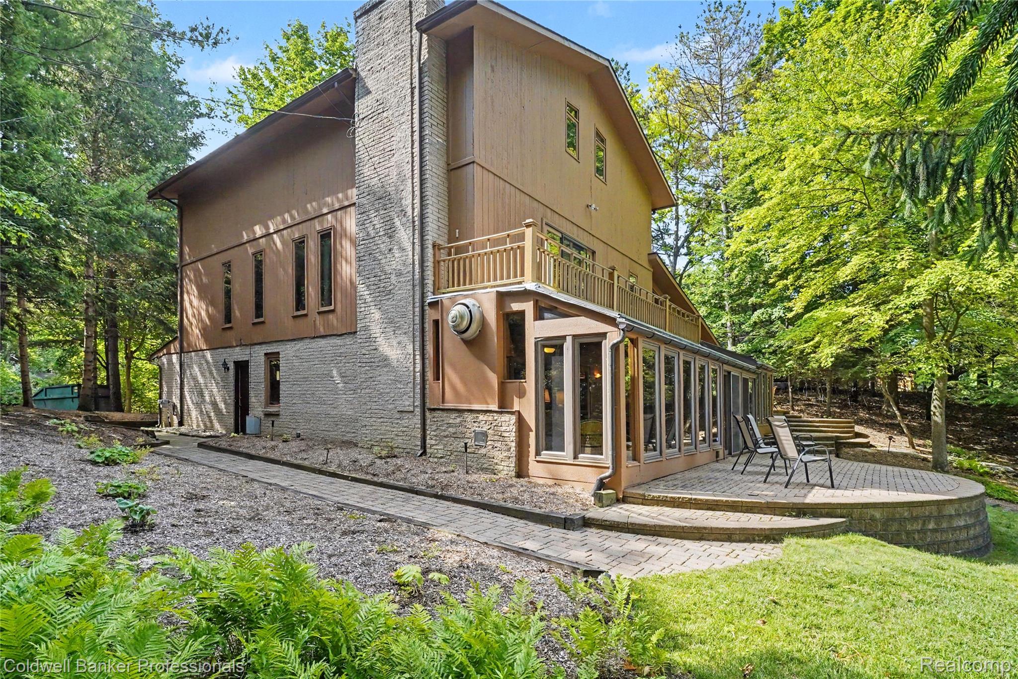 3583 Mitchell Road Metamora, MI 48455 - Photo 1 of 58 Multi-level exterior featuring a stone chimney, a full-length lower-level sunroom, and an upper-level balcony