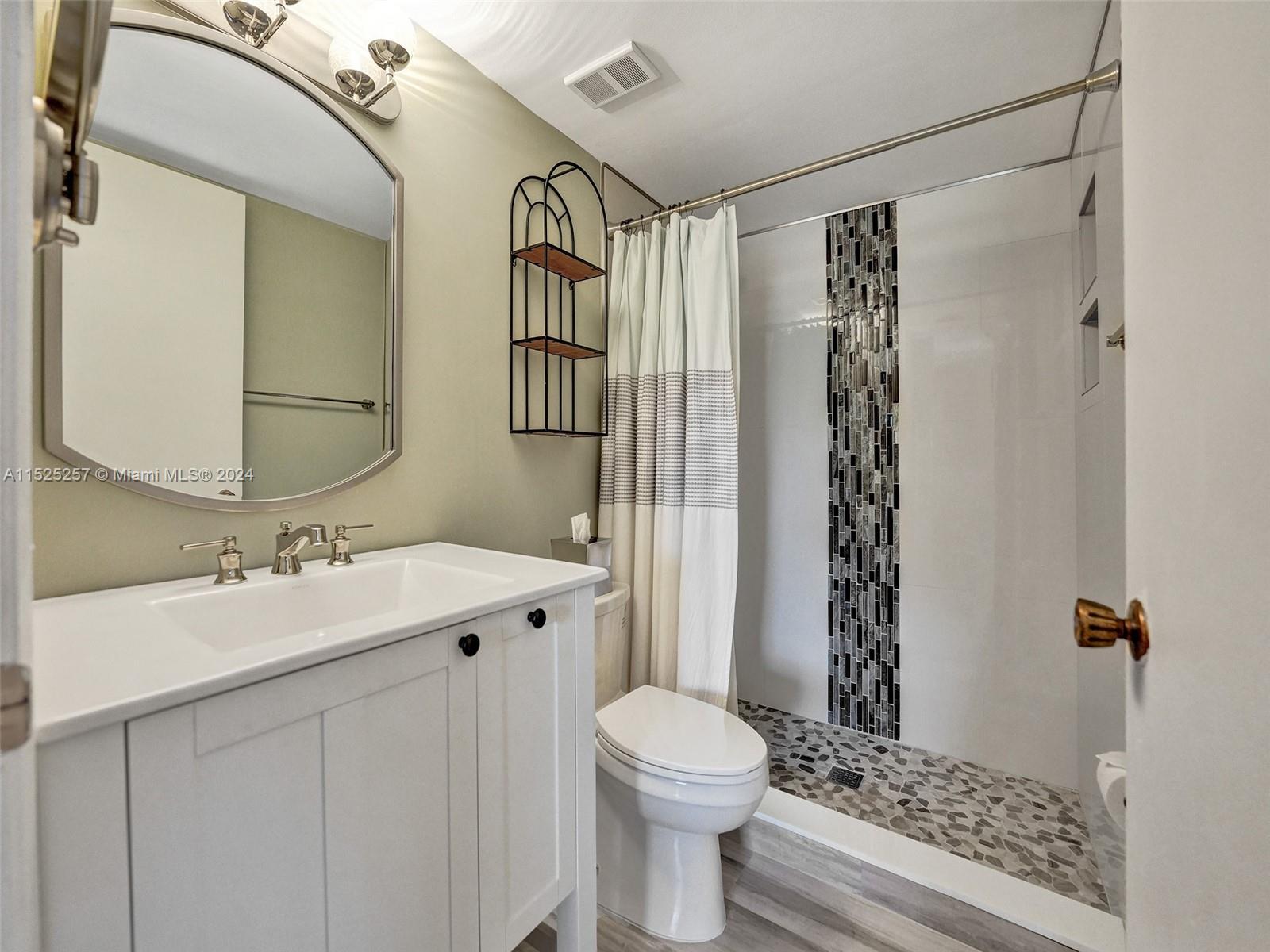 9480 Boca Cove Circle, Unit 416 Boca Raton, FL 33428 - Photo 11 of 25 a bathroom with a sink a toilet and shower