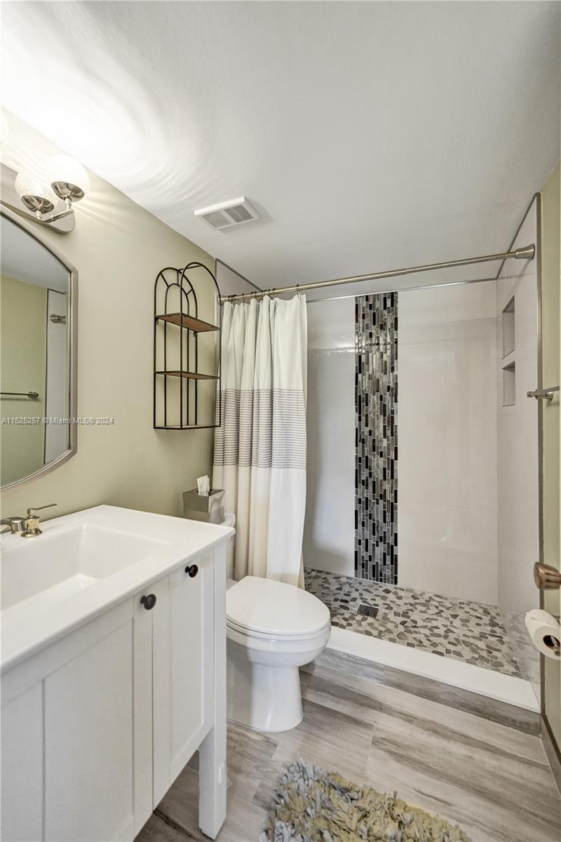 9480 Boca Cove Circle, Unit 416 Boca Raton, FL 33428 - Photo 12 of 25 a bathroom with a sink toilet and shower
