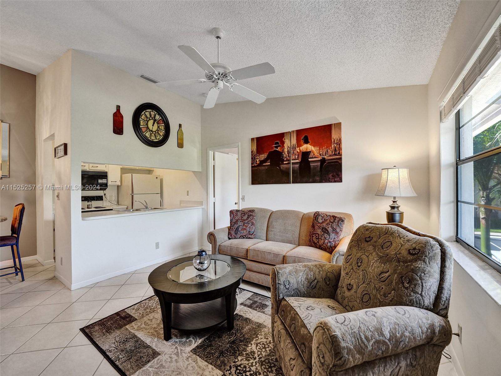 9480 Boca Cove Circle, Unit 416 Boca Raton, FL 33428 - Photo 2 of 25 a living room with furniture and a window