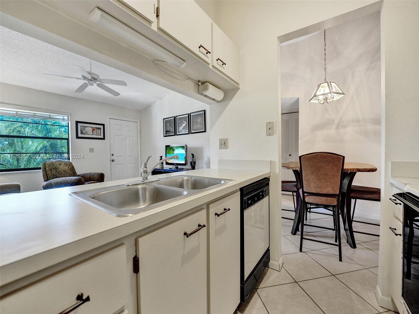 9480 Boca Cove Circle, Unit 416 Boca Raton, FL 33428 - Photo 6 of 25 a kitchen with a sink and chairs