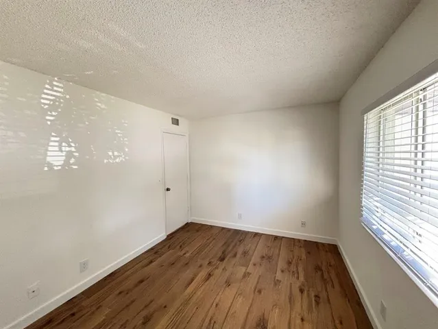 a view of a room with wooden floor and window