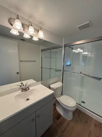 a bathroom with a sink a toilet and shower