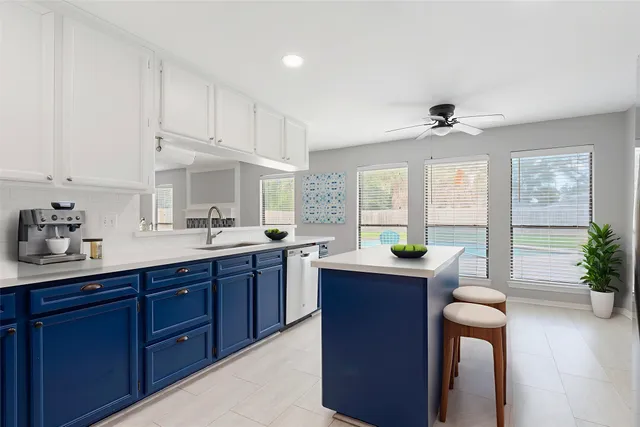 a kitchen with a sink and dishwasher with wooden cabinets