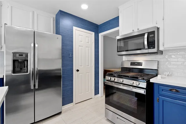 a kitchen with stainless steel appliances granite countertop a refrigerator and a stove