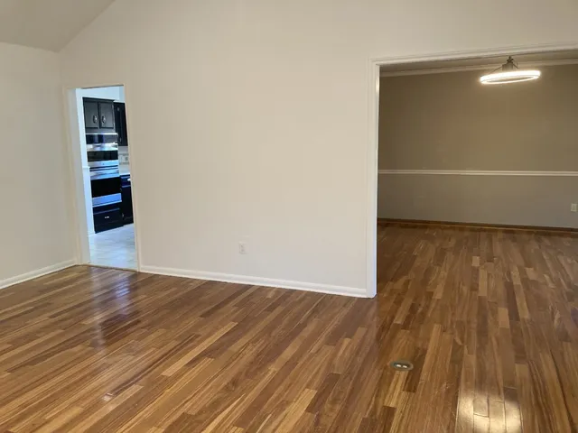 a view of a room with wooden floor and white walls