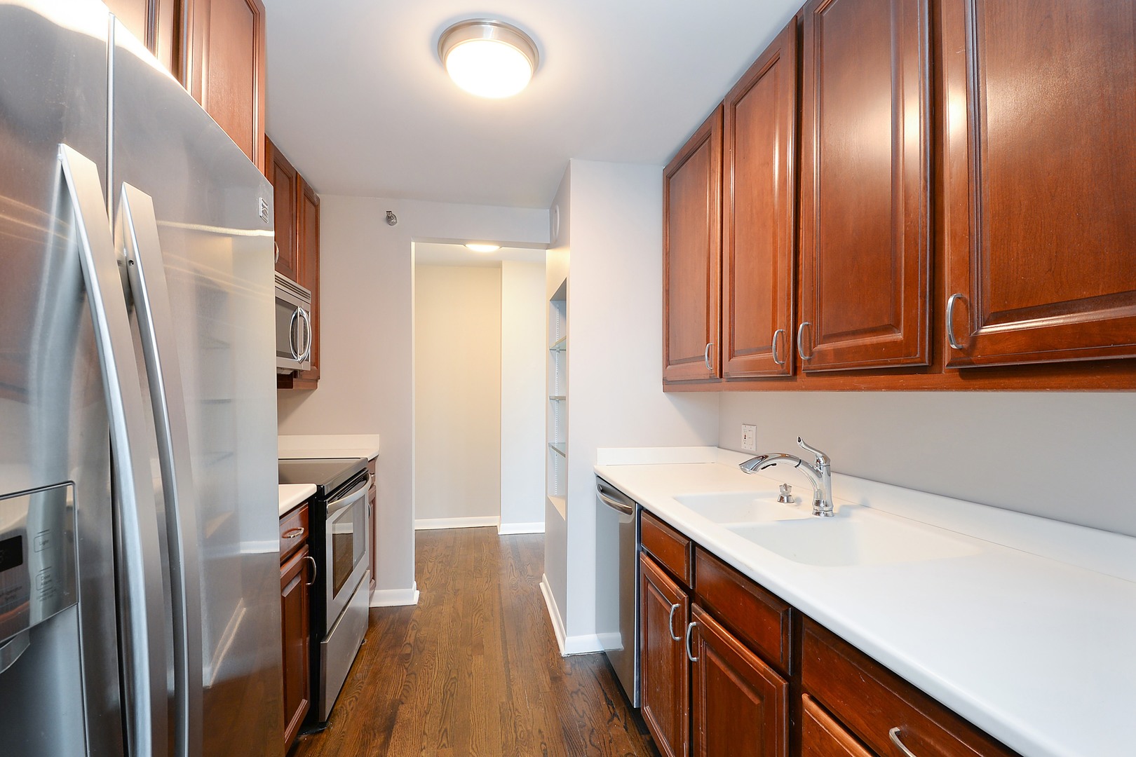 1122 North Clark Street, Unit 1203 Chicago, IL 60610 - Photo 8 of 22 a kitchen with refrigerator cabinets and wooden floor