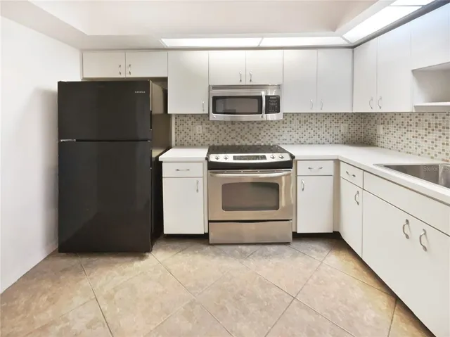 a kitchen with a refrigerator sink and cabinets
