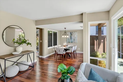 a dining room with furniture a potted plant and wooden floor