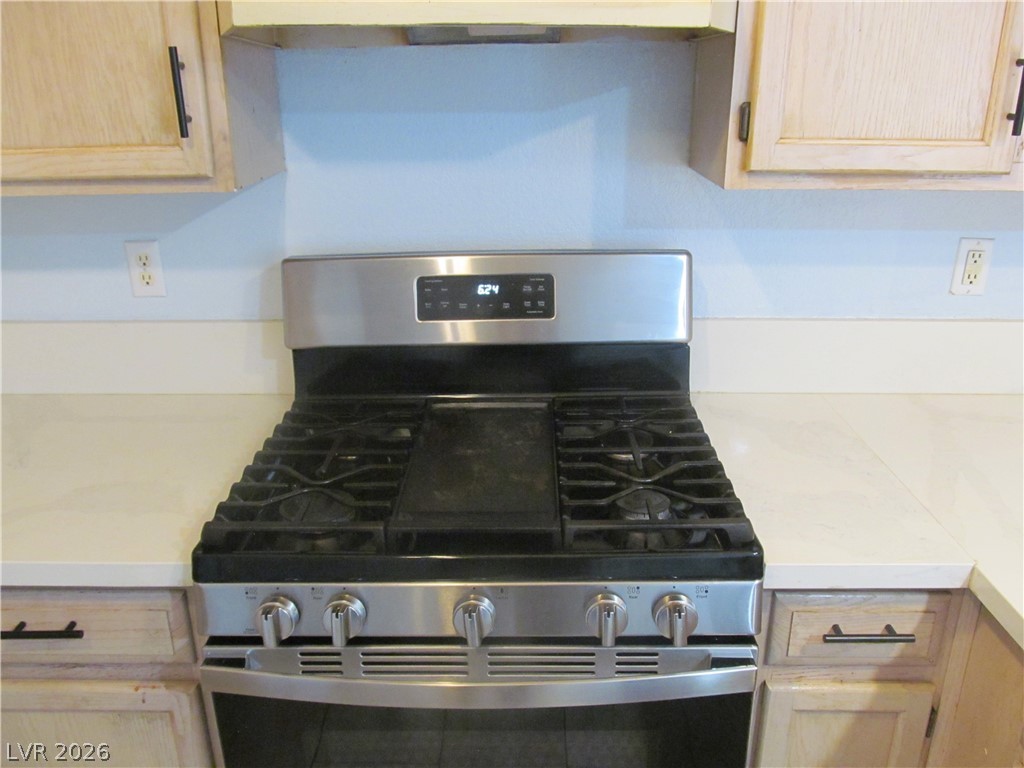 7950 West Flamingo Road, Unit 2048 Las Vegas, NV 89147 - Photo 10 of 24 Culinary delights await with this kitchen's modern gas range, nestled amongst clean countertops and natural wood cabinetry.