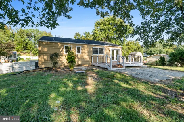 a view of a house with a yard and wooden deck