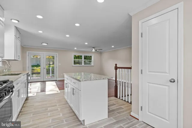 a kitchen with stainless steel appliances white cabinets and a stove top oven
