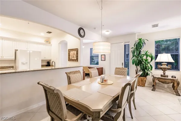 a view of a dining room and livingroom with furniture wooden floor a rug a potted plant and a chandelier