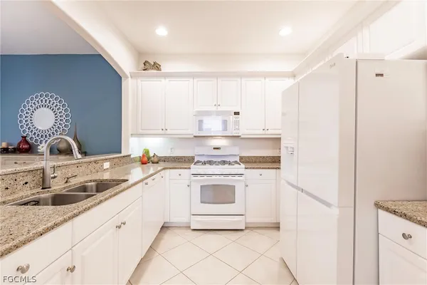 a kitchen with white cabinets and white appliances