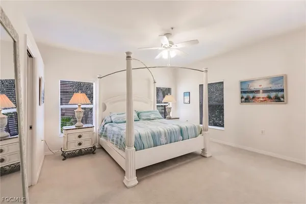 a spacious bedroom with a large bed and a chandelier