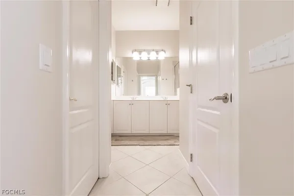 a view of a hallway with chandelier fan