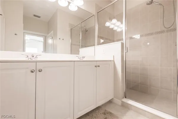 a bedroom with a large bed and a flat tv screen on dresser