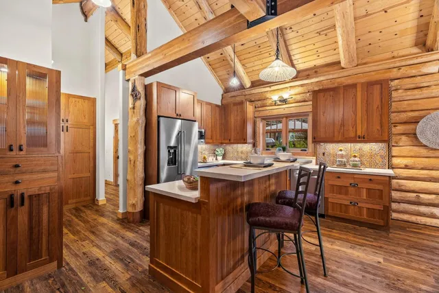 a kitchen with a table chairs refrigerator and cabinets
