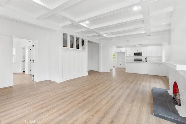 a view of a living room and kitchen with wooden floor