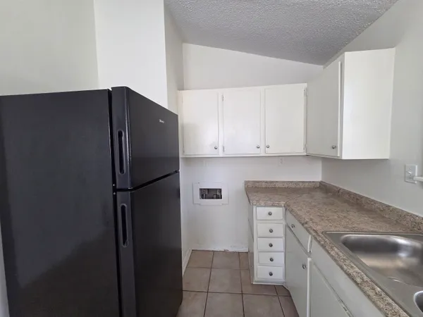 a kitchen with a refrigerator and cabinets