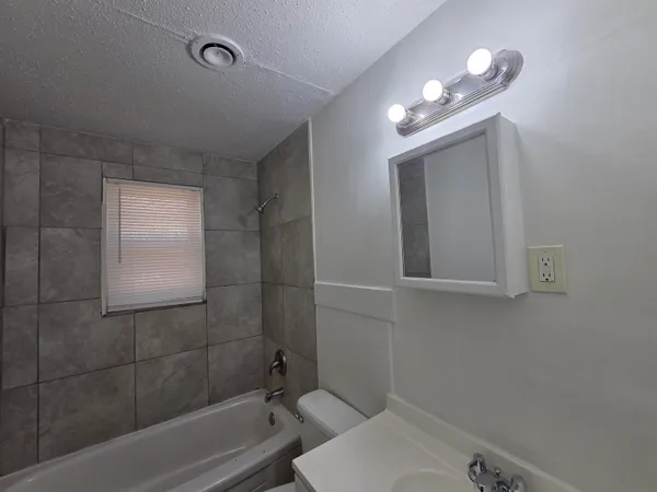 a bathroom with a sink mirror vanity and toilet