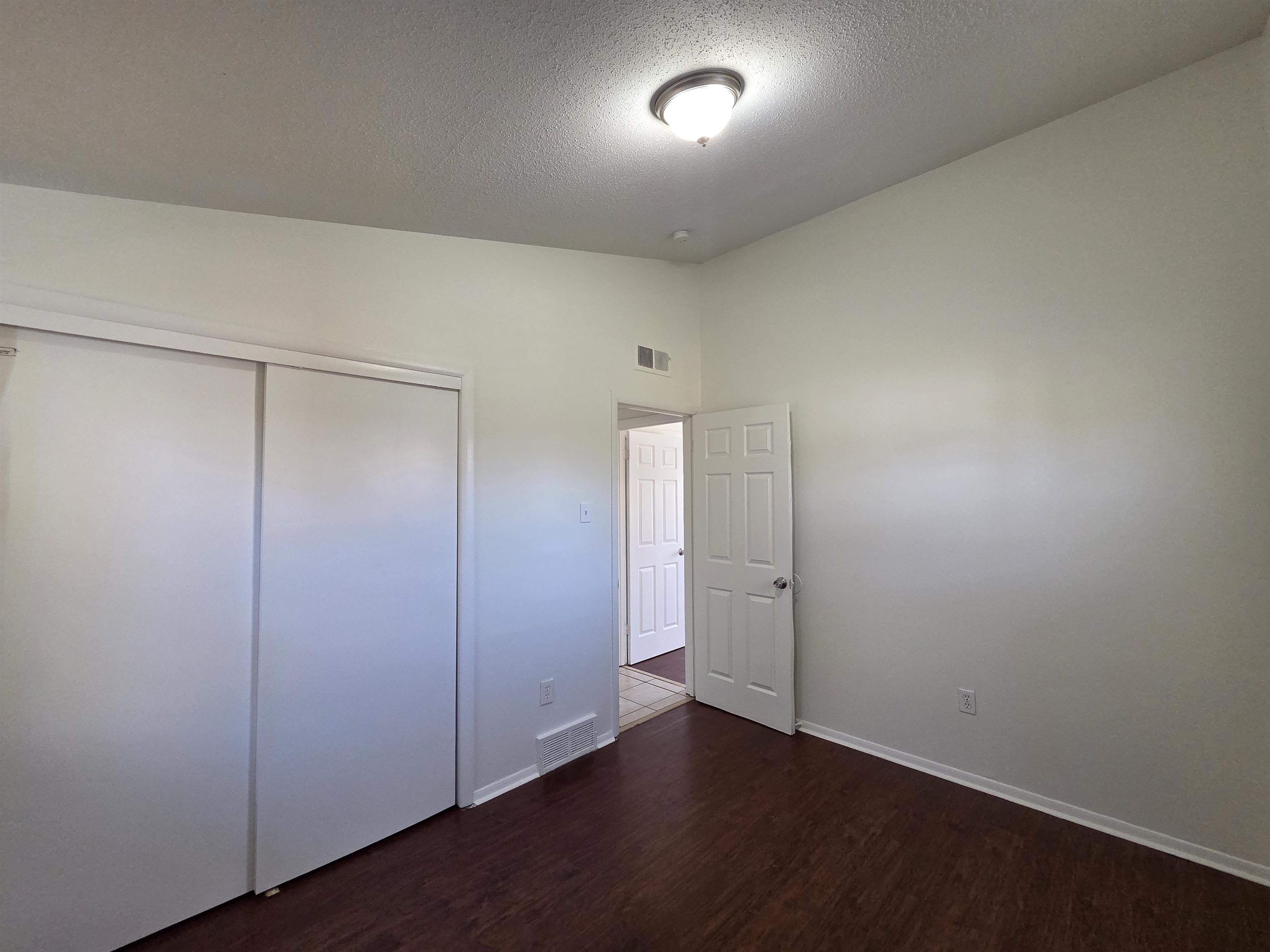 4638 Appleville Street Memphis, TN 38109 - Photo 5 of 23 an empty room with wooden floor and windows