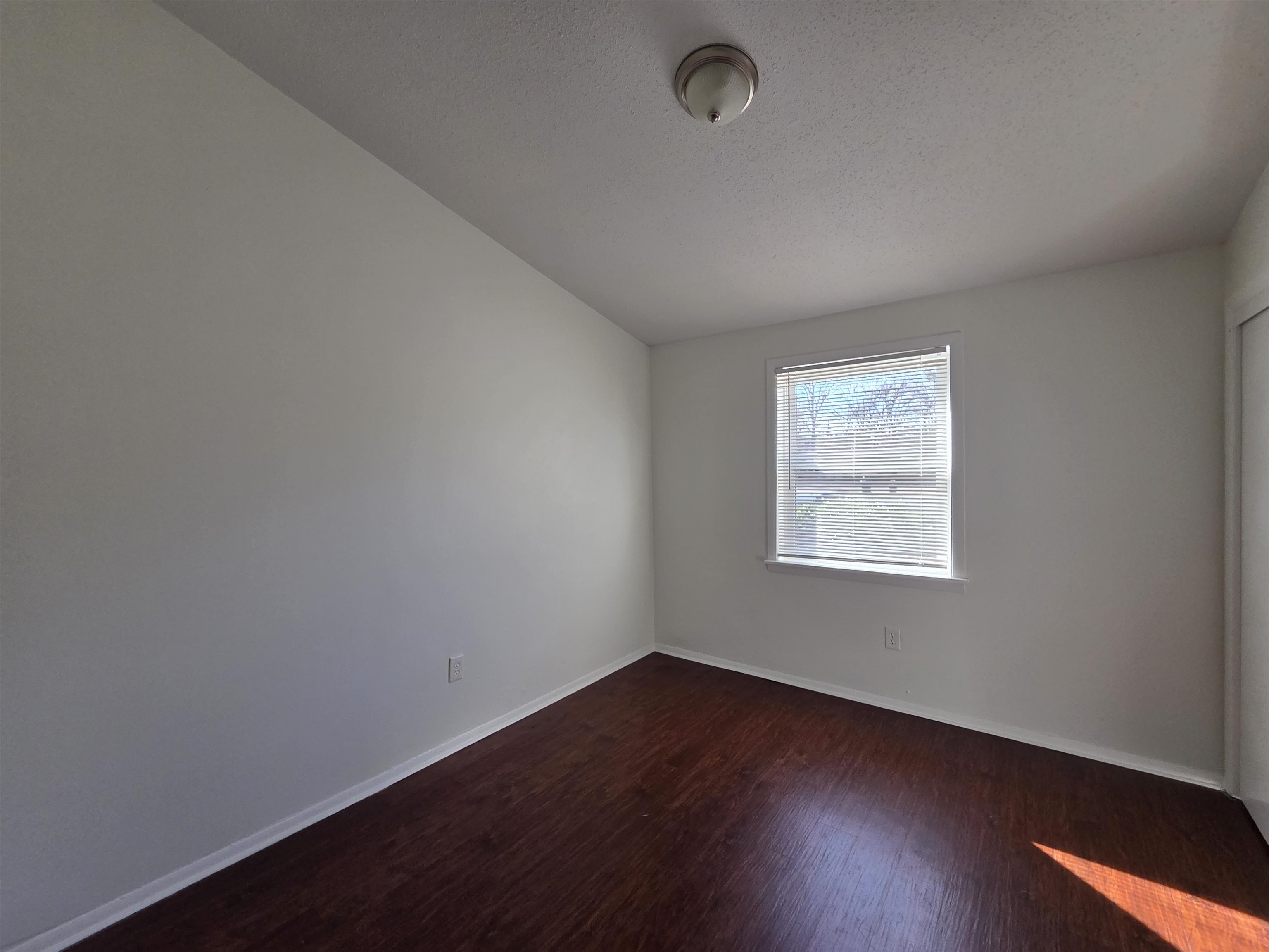 4638 Appleville Street Memphis, TN 38109 - Photo 9 of 23 an empty room with wooden floor and windows