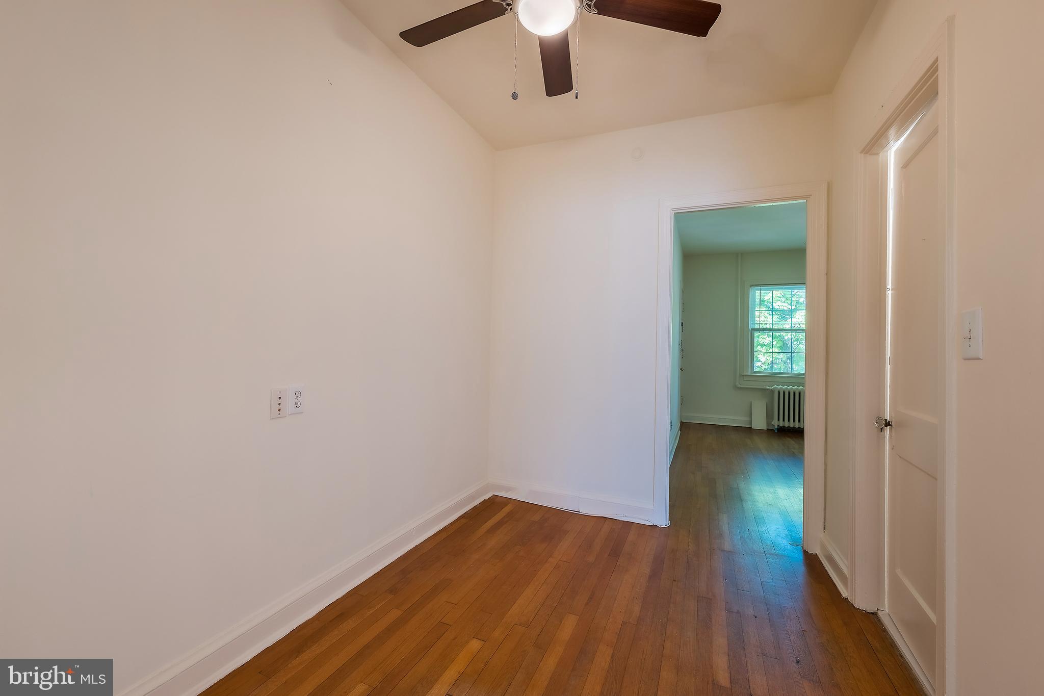 2341 40th Street Northwest, Unit 4 Washington, DC 20007 - Photo 15 of 21 a view of a room with wooden floor a ceiling fan and a window