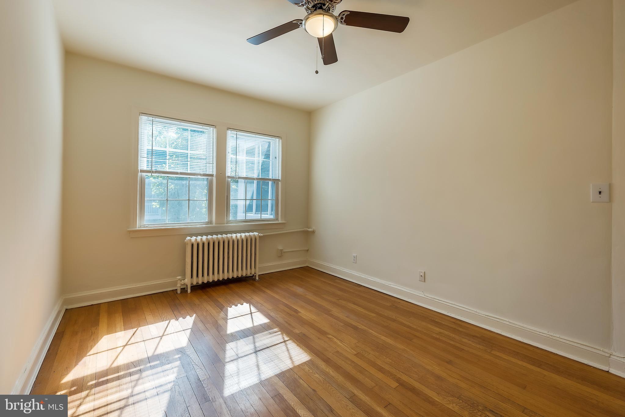 2341 40th Street Northwest, Unit 4 Washington, DC 20007 - Photo 17 of 21 an empty room with wooden floor fan and windows