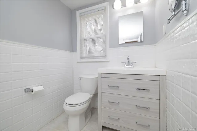 a bathroom with a toilet a sink a vanity and mirror