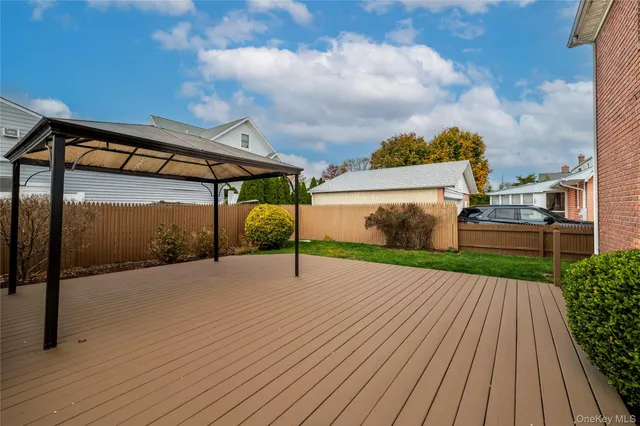 a view of a house with a yard and table and chairs under an umbrella