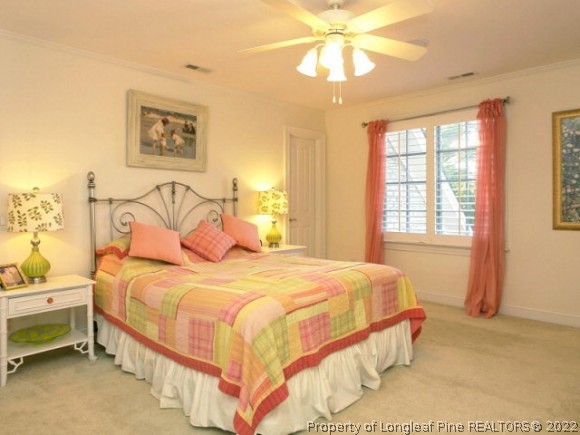 550 Tilghman Road Coats, NC 27521 - Photo 3 of 27 a bedroom with a bed and a chandelier