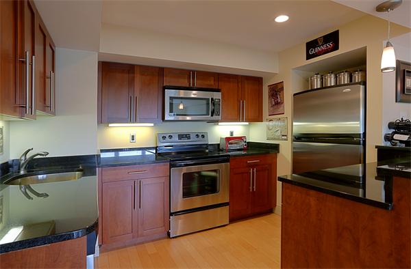 a kitchen with granite countertop a refrigerator stove and microwave