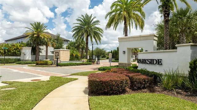 a kitchen with stainless steel appliances granite countertop a dining table chairs refrigerator and sink