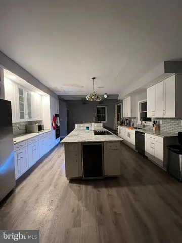 a view of living room kitchen with furniture and chandelier