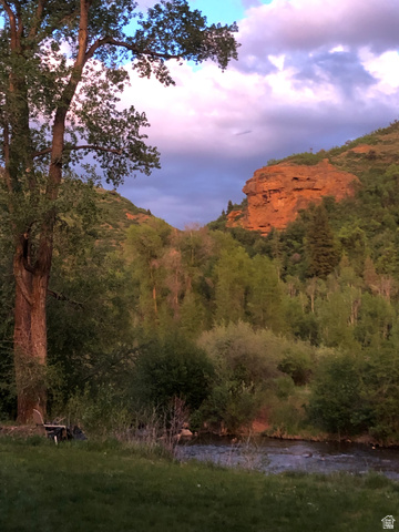 13581 13581st Huntsville, UT 84317 - Photo 2 of 11 Expansive natural landscape featuring a flowing river, mature trees, verdant foliage, and distant red rock formations