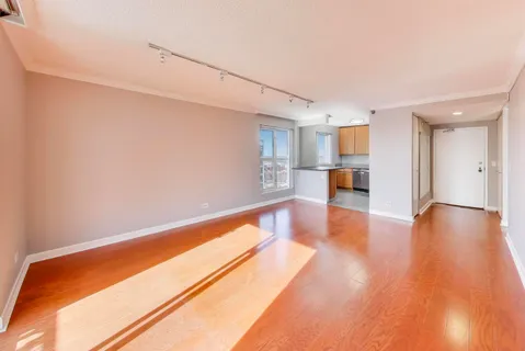 a view of an empty room with wooden floor