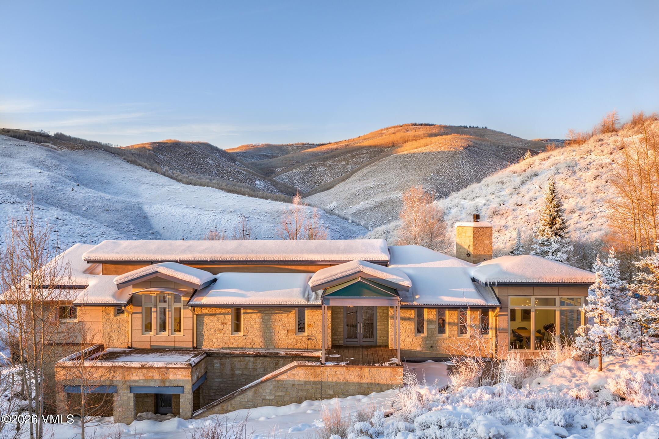 4340 June Point Avon, CO 81620 - Photo 41 of 43 a view of a large house with a yard and table and chairs under an umbrella