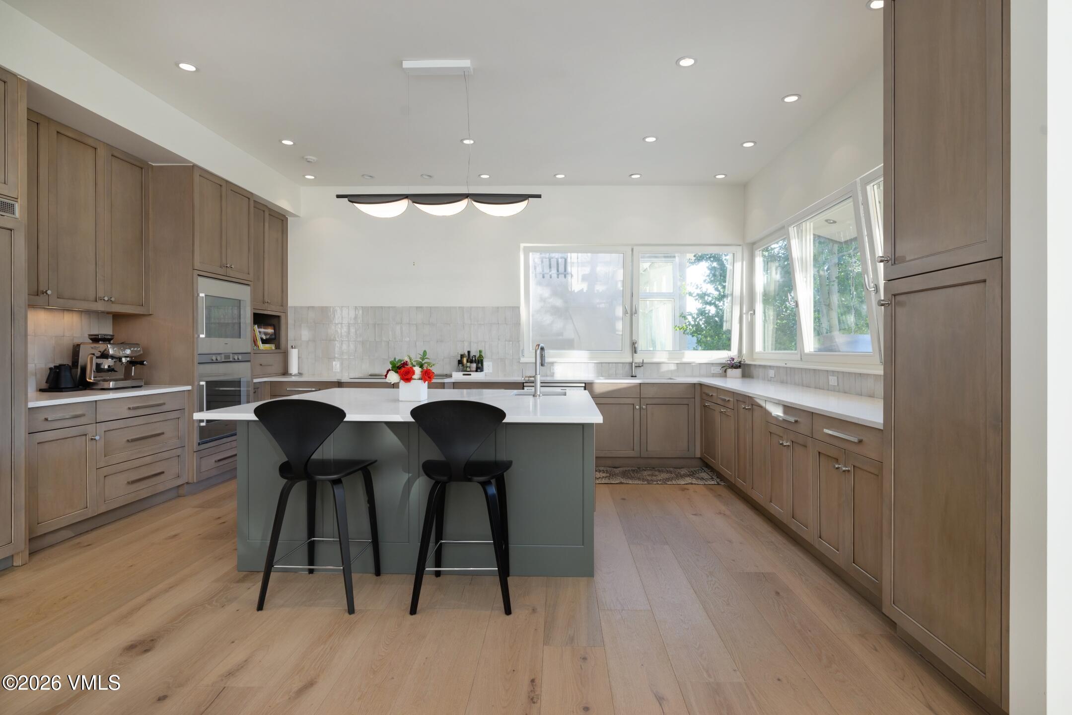 4340 June Point Avon, CO 81620 - Photo 8 of 43 a kitchen with a sink a counter top space a large window and stainless steel appliances