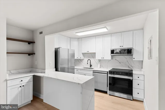 a kitchen with stainless steel appliances a sink and a refrigerator
