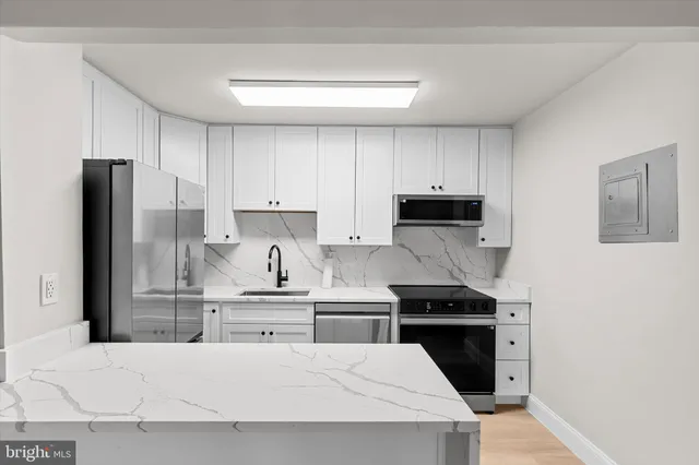 a kitchen with white cabinets and stainless steel appliances