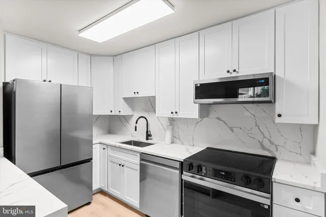 a kitchen with granite countertop a refrigerator stove and microwave