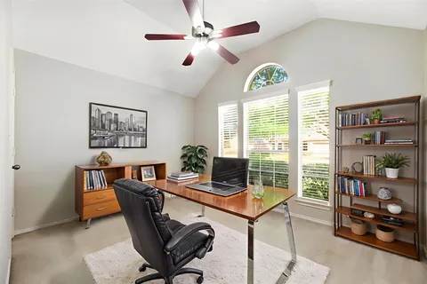 a view of a workspace with furniture and a floor to ceiling window