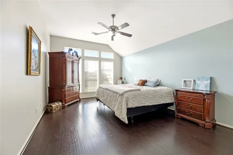 a bedroom with a bed dresser and a large window