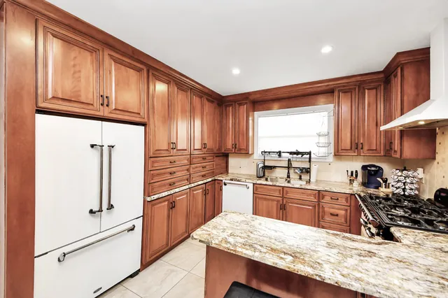 a kitchen with stainless steel appliances granite countertop a refrigerator sink and cabinets